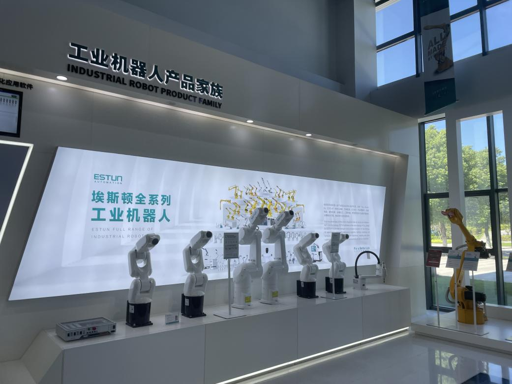 The industrial robot product family display in the Estun exhibition hall, showing the full range from small six-axis models to heavy-payload machines