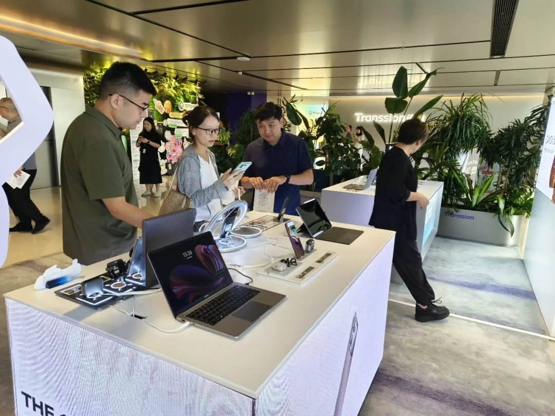 Visitors trying devices in the product experience area at Transsion's Shenzhen headquarters