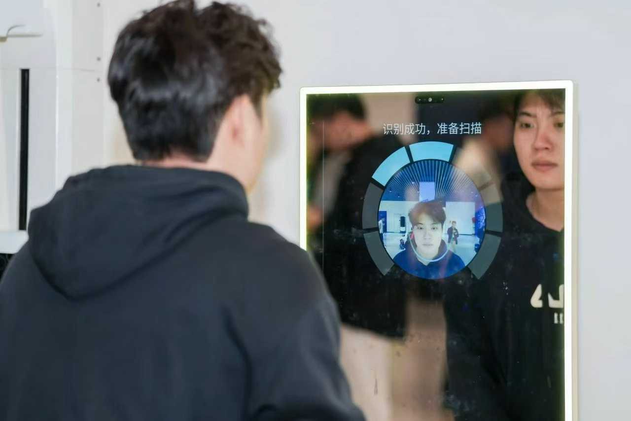 A visitor trying the smart mirror face recognition demonstration in the DeepBlue exhibition hall