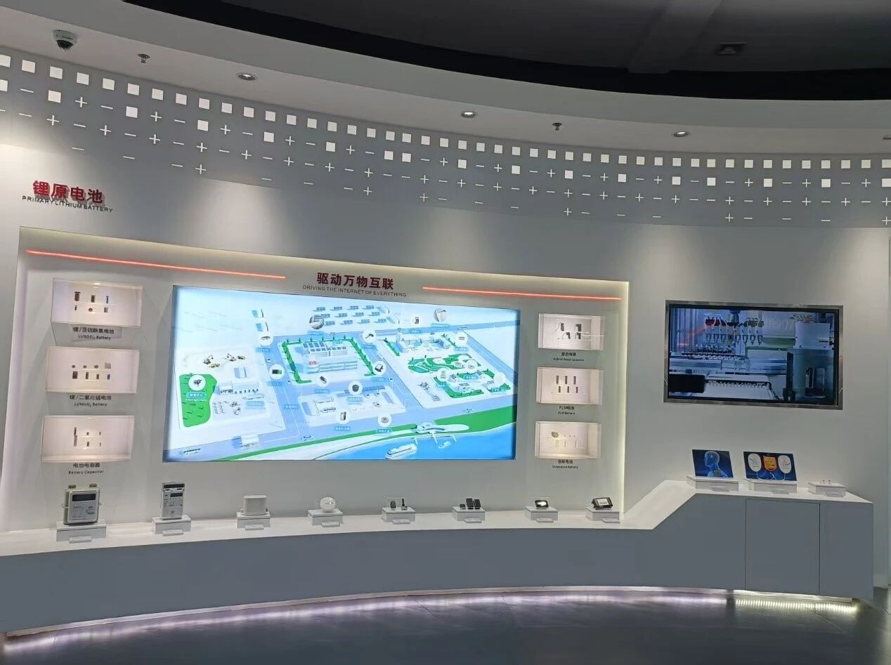 The EVE Energy exhibition hall in Huizhou, with the primary lithium battery wall and a panorama screen reading 'Driving the Internet of Everything'
