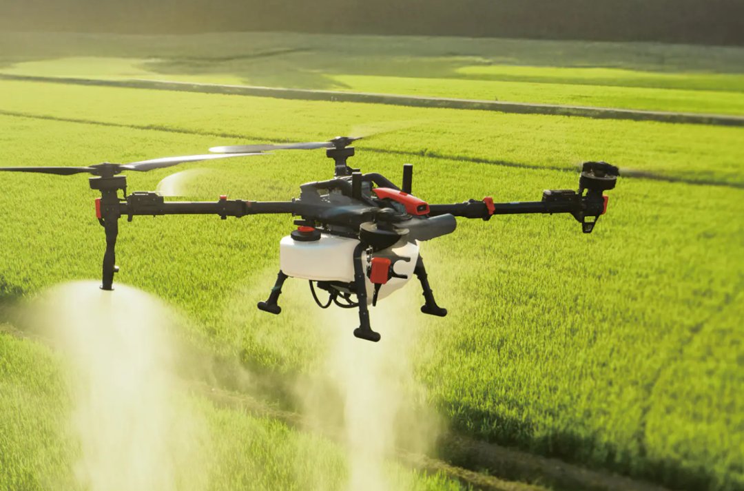 An XAG agricultural drone spraying crops over a field during a demonstration.